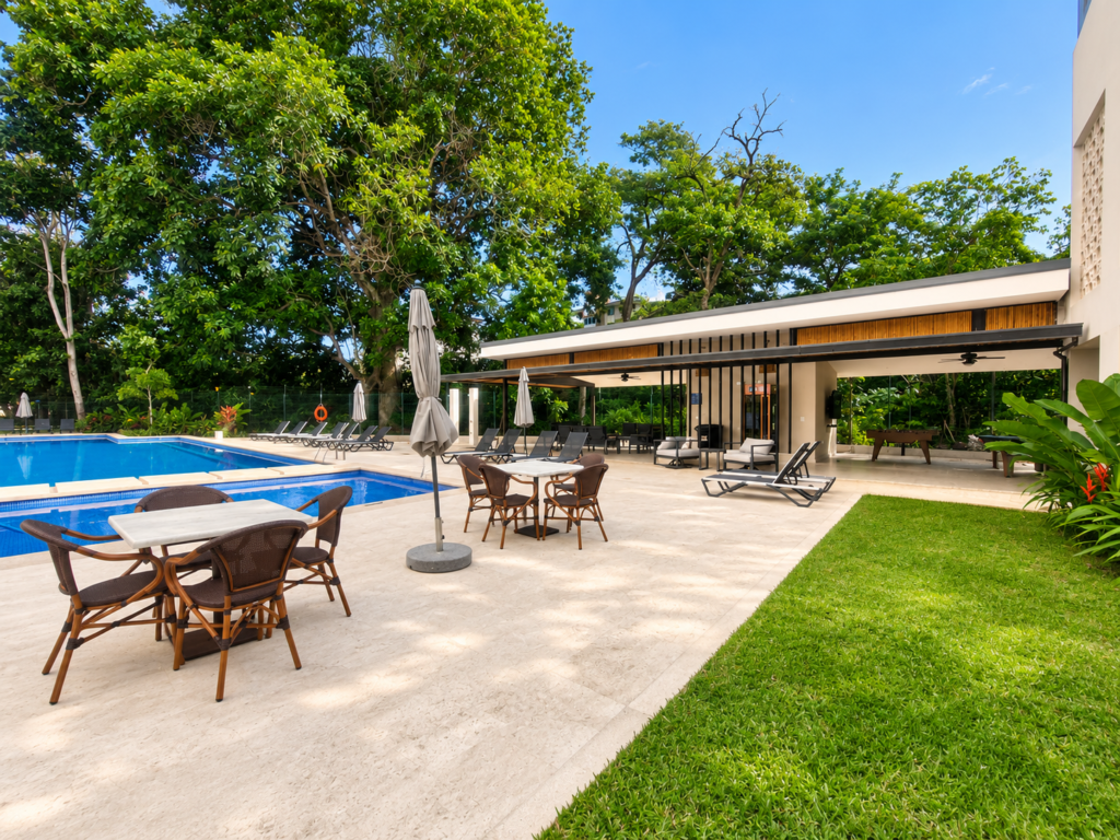 Outdoor tables and seating beside the pool at Casa Live 1708