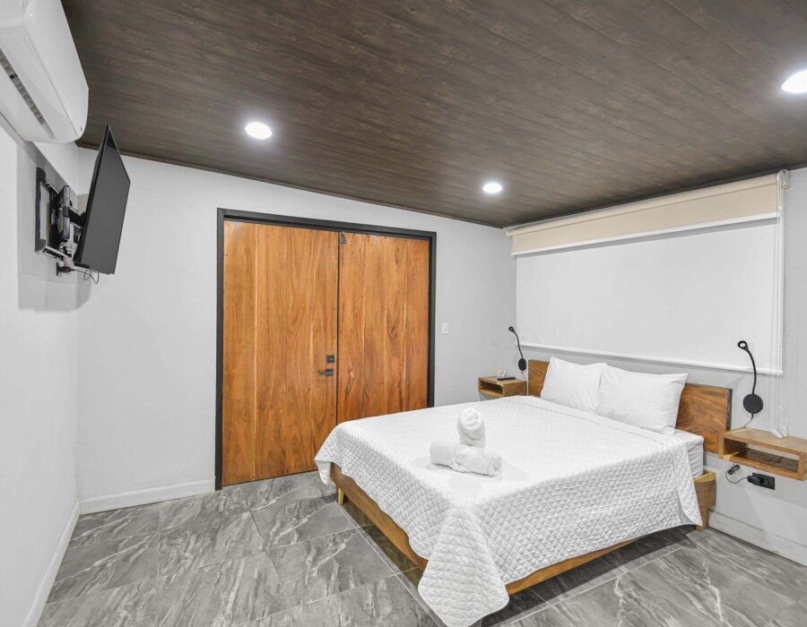 modern bedroom with double bed and AC and TV in seven ranch