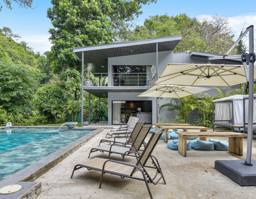 Benches, poufs, and umbrellas in the poolside garden at Seven Ranch