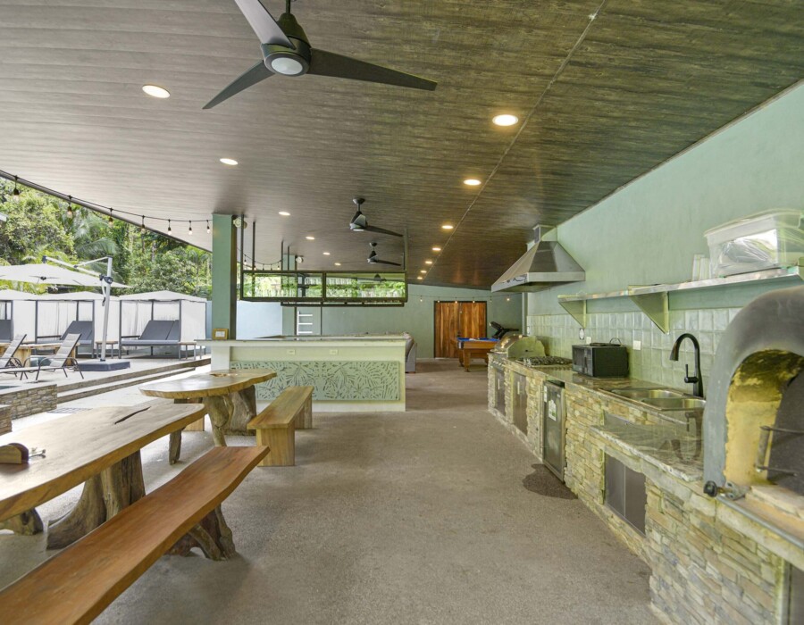 Barbecue area with table for 16 people, pizza oven, BBQ, mini bar, and garden views at Seven Ranch