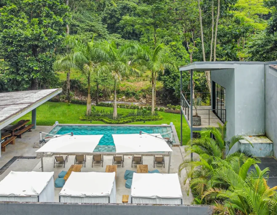 Drone view of the pool, river, garden, and loungers at Seven Ranch