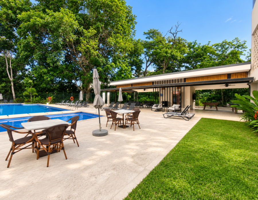 Outdoor tables and seating beside the pool at Casa Live 1708